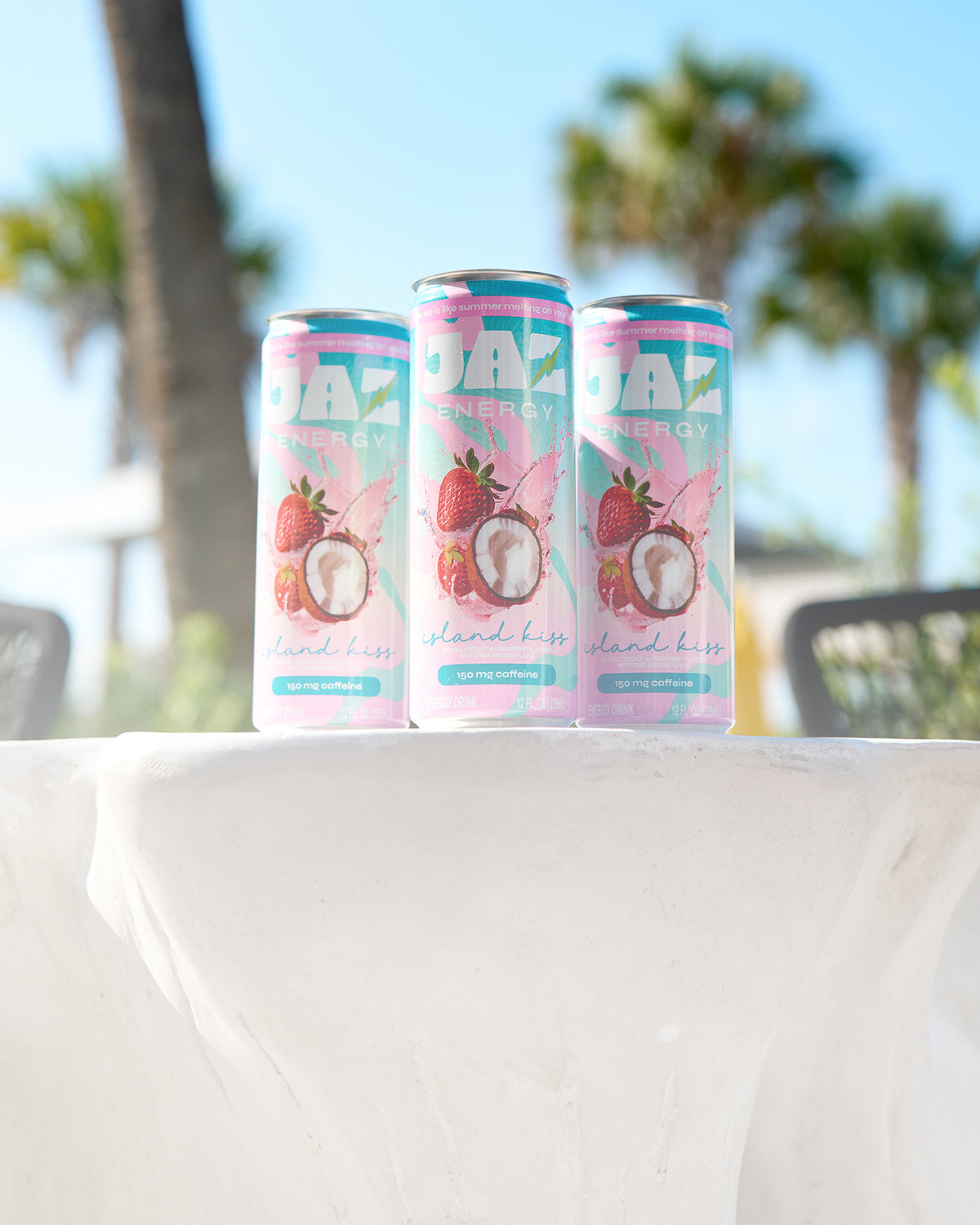 Three Jaz Energy cans on the beach – clean energy drinks for an active, outdoor lifestyle with no crash.