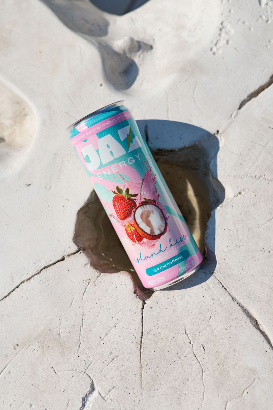 Canned drink with strawberry and coconut design on a rocky surface