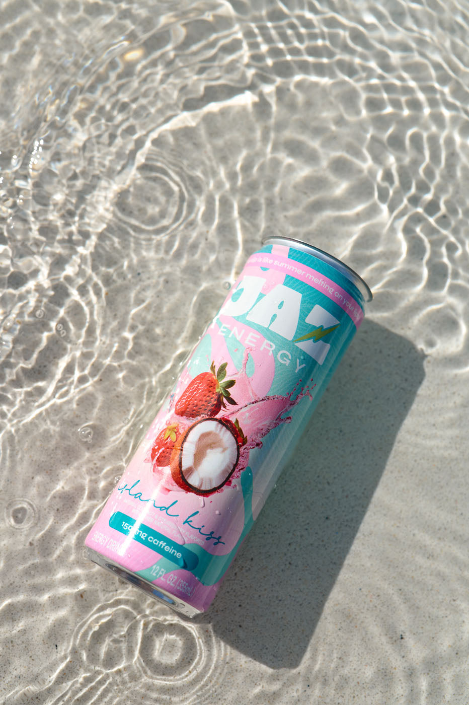 Jaz energy drink can with strawberry and coconut design on a sandy beach