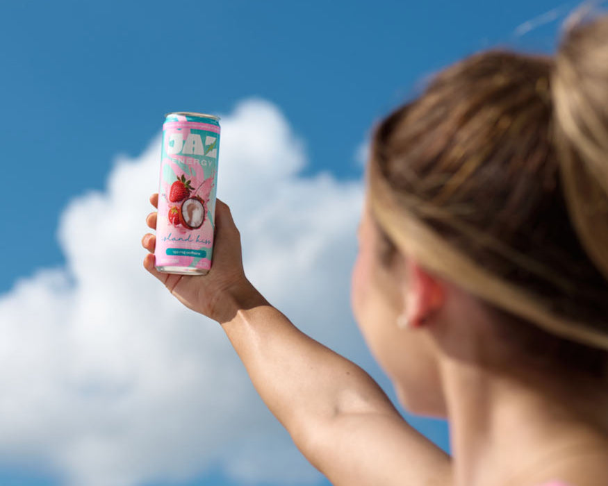 Person holding a can against a blue sky with clouds